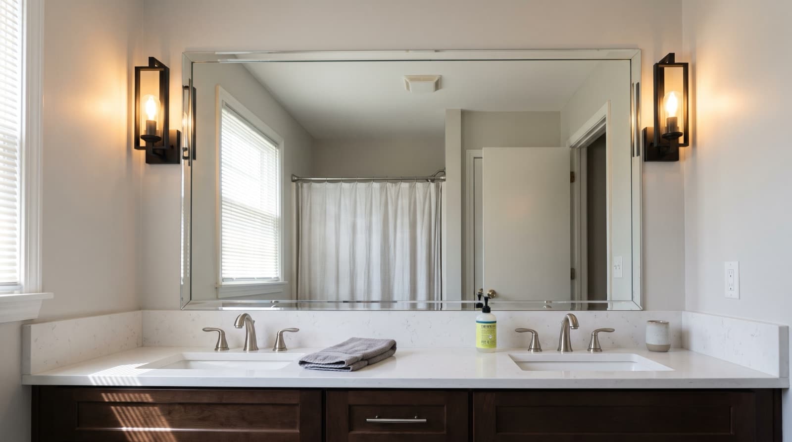 Large frameless wall mirror above a double bathroom vanity