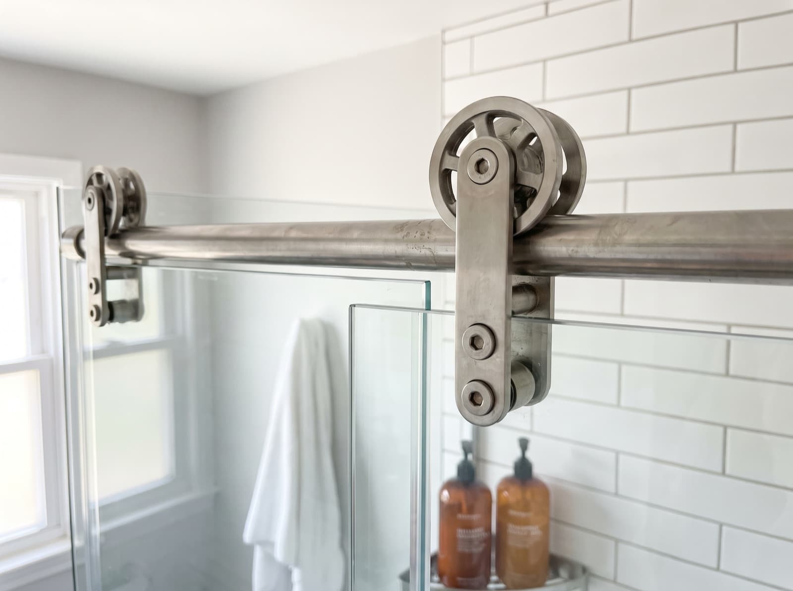 Close-up of the rollers and header rail on a sliding shower door