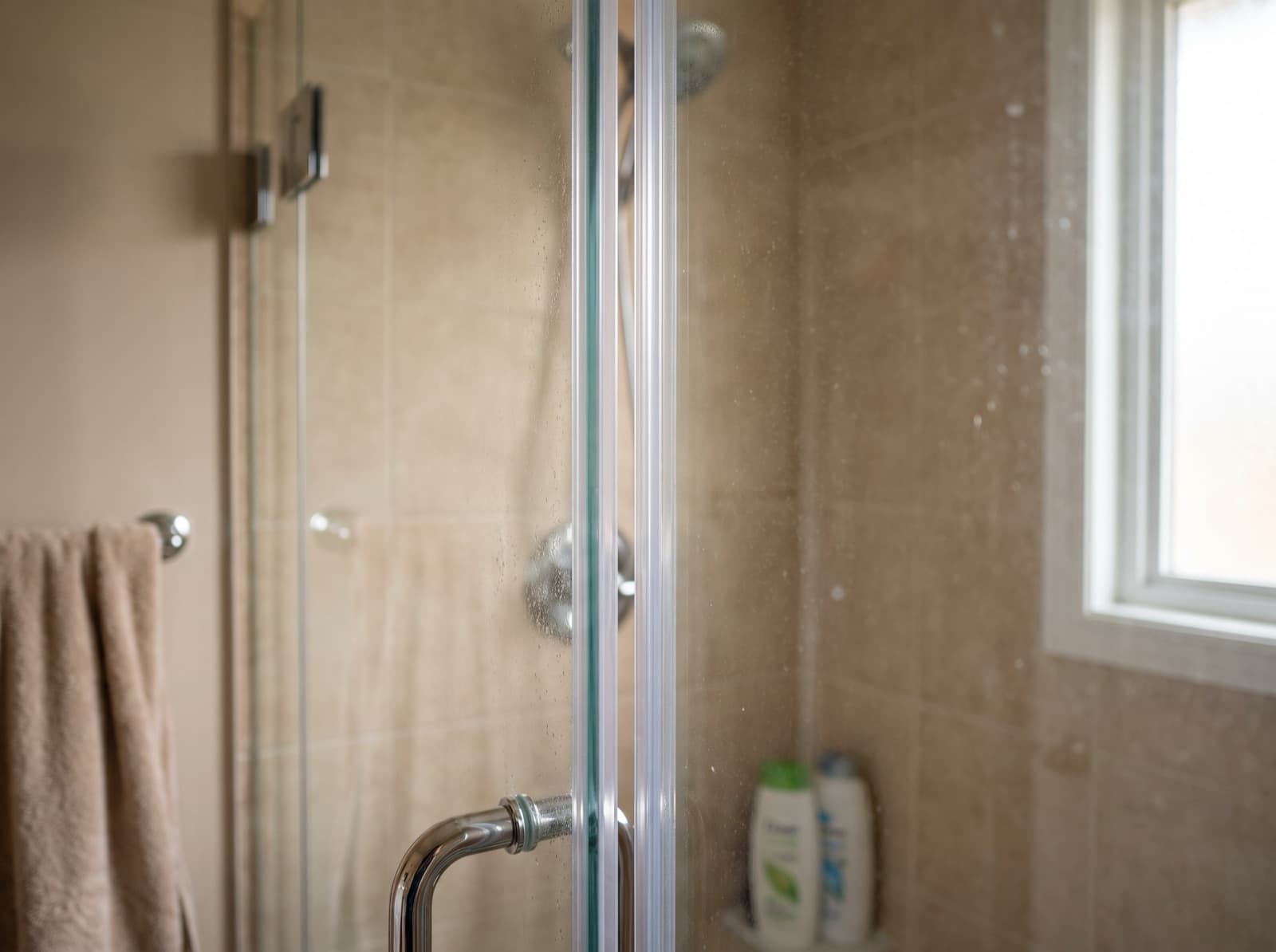 Close-up of a clear vinyl seal on the edge of a steam shower glass door